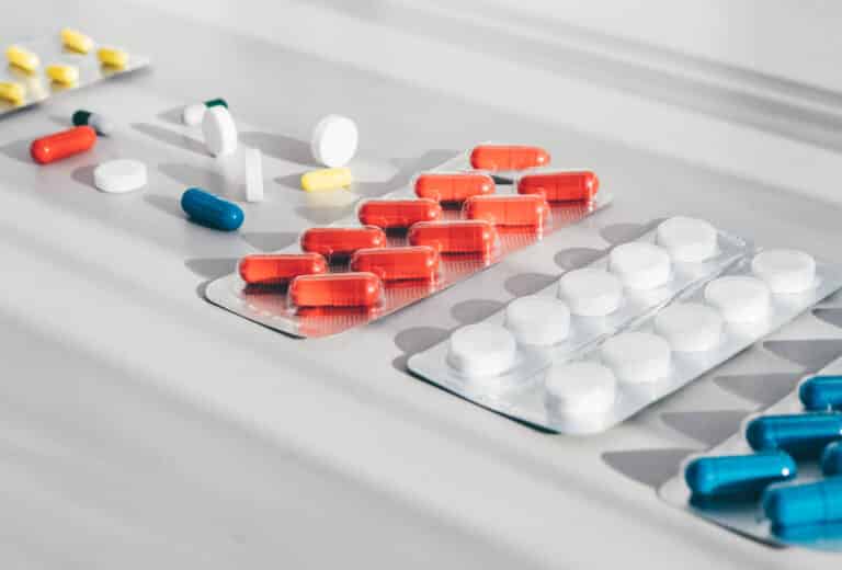 Medicine pills, tablets and capsules on white background. Top view